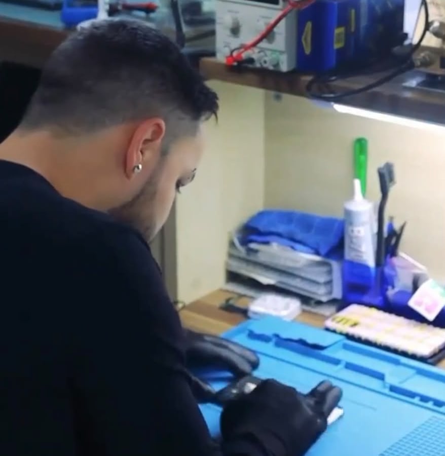 técnico consertando um celular na bancada da CAC Phone